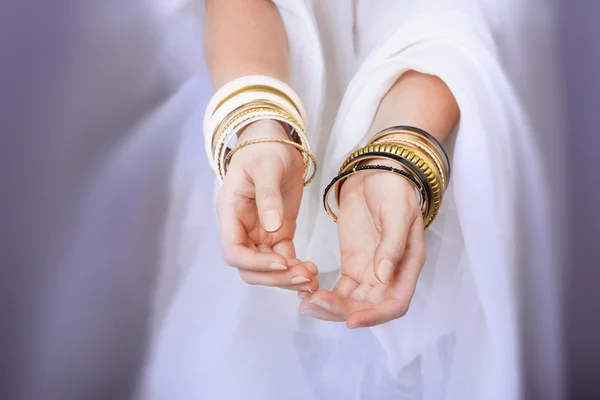 Girl hands with golden bracelets — Stock Photo, Image