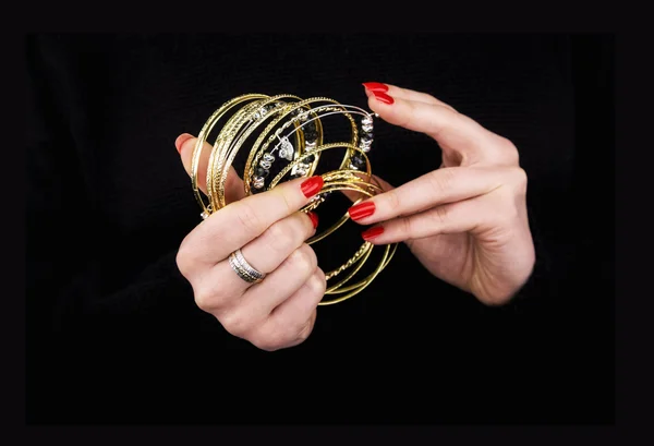 Женские руки с золотыми браслетами — стоковое фото