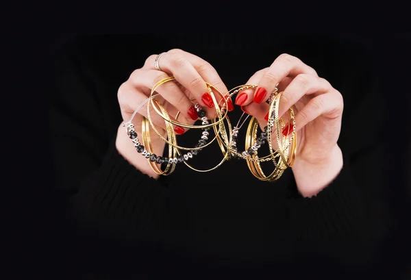 Frauenhände mit goldenen Armbändern — Stockfoto