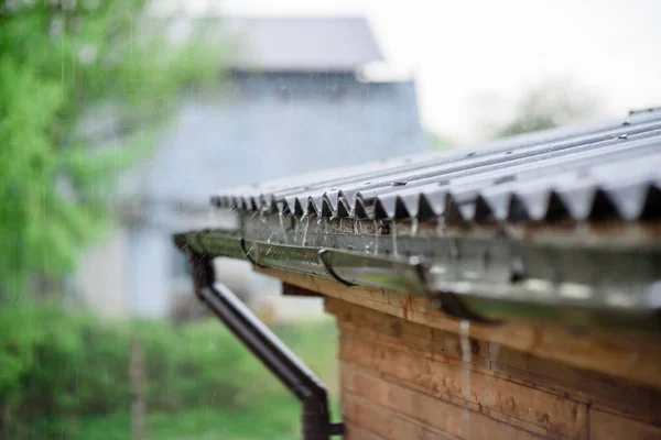 Rain water falling down from house roof in rainy season.