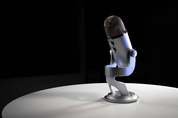 Üzerinde ayarlanabilir masa üstü durağı olan gri USB yoğunlaştırıcı mikrofon koyu renkli renkli parlak renkli ve fotokopi alanı olan beyaz bir kontrast odasında duruyor.