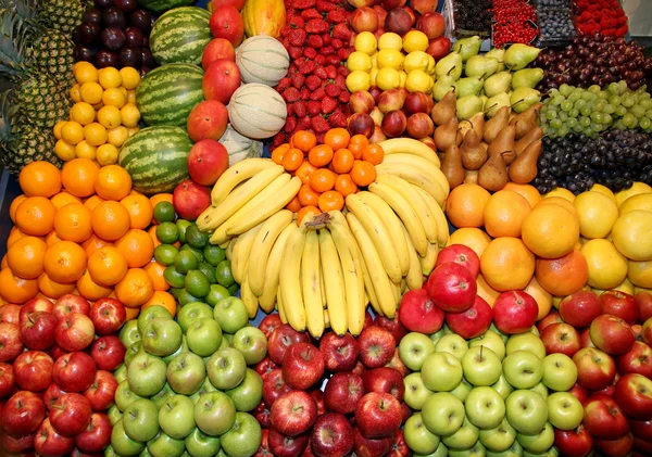 Primer plano de muchas frutas coloridas en el stand del mercado — Foto de Stock