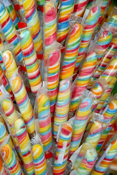 Dulces piruletas de colores en el mercado callejero como fondo —  Fotos de Stock