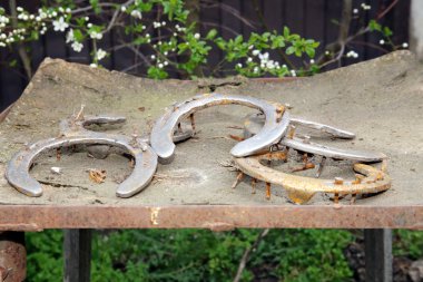 Kırsal at çiftliğinde bir arka plan olarak beş eski paslı nal 