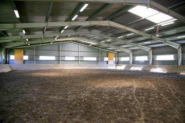 Empty riding hall with sandy covering  clipart