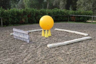 Image of an empty training field. Barriers for schooling horses as a background. Colorful photo of equestrian obstacles. Empty field for horse training event  clipart