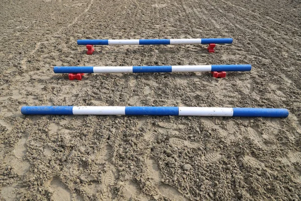 Image of an empty training field. Barriers for schooling horses as a background. Colorful photo of equestrian obstacles. Empty field for horse training event