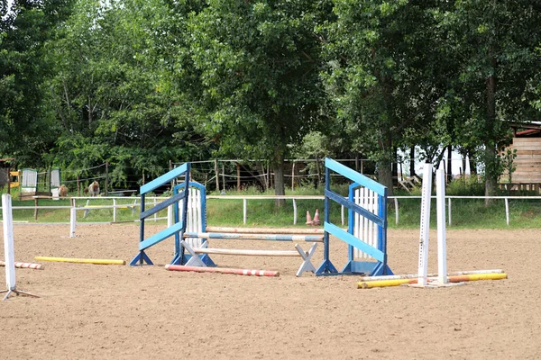 Image of an empty training field. Barriers for schooling horses as a background. Colorful photo of equestrian obstacles. Empty field for horse training event