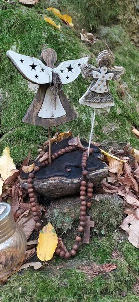 Beautiful angel decorations with wings on back in vintage garden. Angel statue against green mossy stone. Interior of abandoned garden with angel statue with mossy green leaves