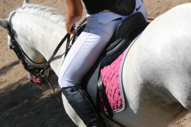 Yaz mevsiminde, atlama yarışında yarışan bilinmeyen bir yarışmacı. Atlayan atı eyer altında göster