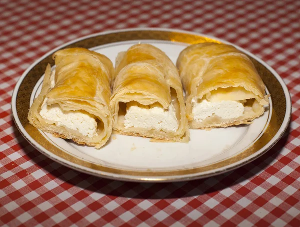 Cottage cheese strudel on checkered tablecloth — Stock Photo, Image