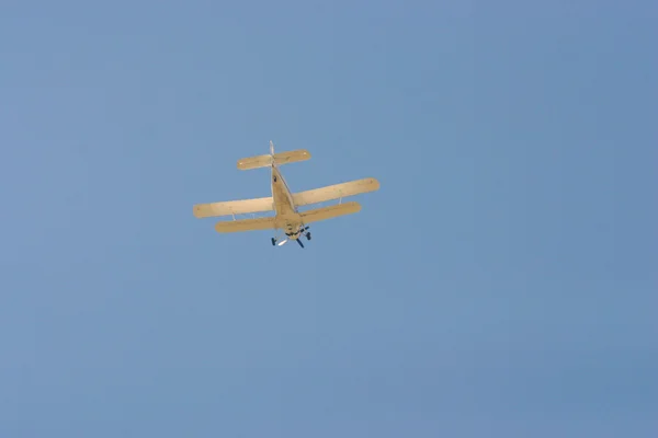 Estilo retro biplano flyinng en el aire contra el cielo azul —  Fotos de Stock