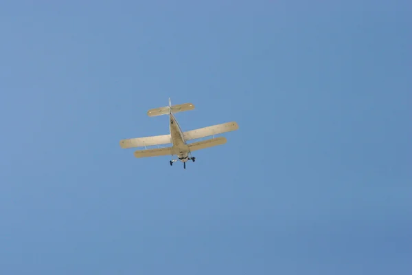 Biplan flyger i den blå himlen — Stockfoto