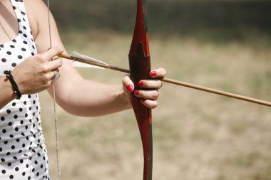 Arrow and bow in hands of an unidentified archer clipart