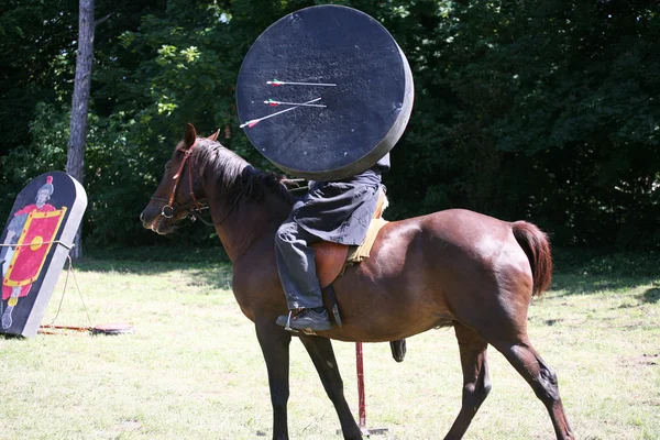 Soldat i historiska kläder på sin häst med mål och PI — Stockfoto