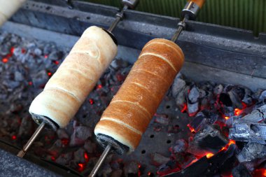 Kömür ateşinin üzerinde tükürük pişiren baca keki. Açık hava pazarında baca keki pişirmek. Kurtosh Kalach Transilvanya 'dan geleneksel Macar yemeğidir.