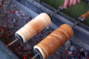 Kömür ateşinin üzerinde tükürük pişiren baca keki. Açık hava pazarında baca keki pişirmek. Kurtosh Kalach Transilvanya 'dan geleneksel Macar yemeğidir.