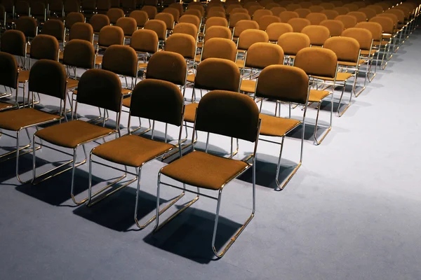 Righe di sedie vuote preparate per un evento al coperto — Foto Stock