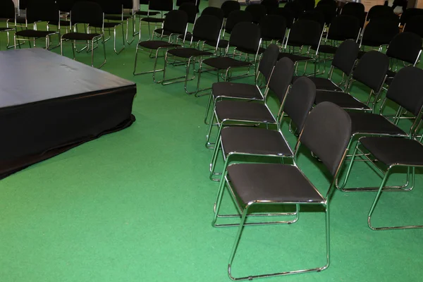 Filas de sillas vacías en una sala de seminarios con escenario pequeño —  Fotos de Stock