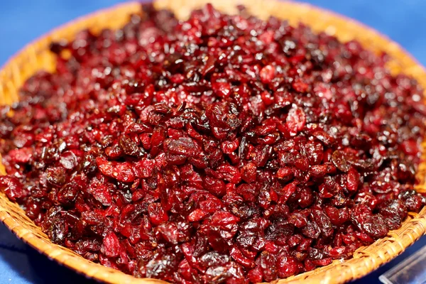Cranberries vermelhas secas em uma tigela rústica na mesa azul. Selectivo — Fotografia de Stock