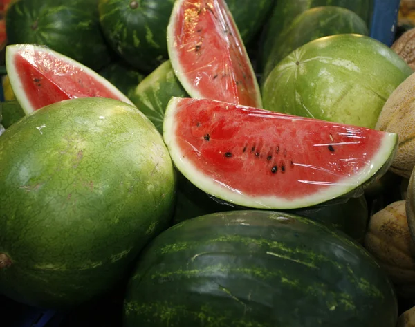 Fresh sweet water melons on market stall as background