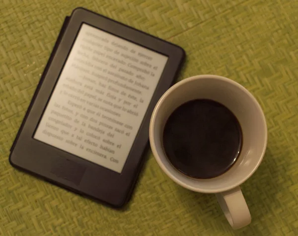 Porselen kahve fincanı ve kitap pencerenin önünde.