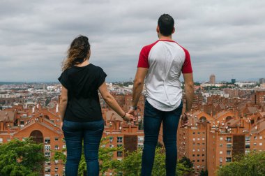 Genç çift parkta öpüşüyor ve gülüyor.