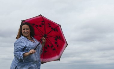 Parkta kırmızı şemsiyeli genç kız.