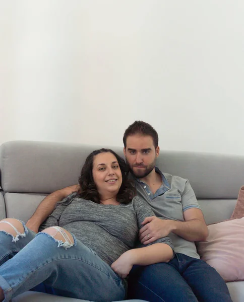 Schwangere Hochzeitspaar Sitzt Auf Sofa Und Schaut Einander Und Lächelt — Stockfoto