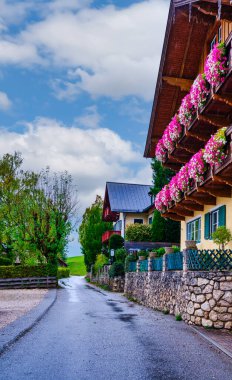 Dikey: Büyüleyici alp tarzı evler St. Wolfgang 'da pitoresk bir cadde çiziyor, balkonları renkli çiçeklerle dolup taşıyor. Salzkammergut, Avusturya