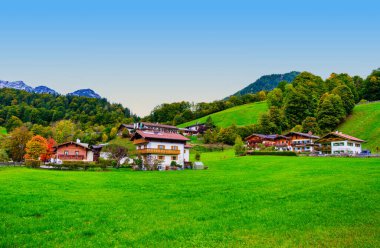 Geleneksel alp yarım kereste evleri Ramsau bei Berchtesgaden 'in görkemli köyünün verimli, yuvarlak tepelerinde yuva yapar. Bavyera, Almanya