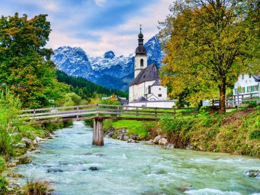 Sembolik St. Sebastian Kilisesi ve Ramsauer Ache nehrinin kıyısında güzel sonbahar renkleriyle çevrili geleneksel alp evleri. Ramsau bei Berchtesgaden, Almanya
