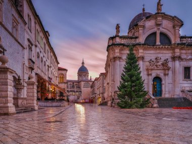 Huysuz bir alçak açı çekimi, Katedral 'in ve St. Blaise Kilisesi' nin Eski Şehir 'in yağmura bulanmış kireçtaşı kaldırımındaki yansımasını yakalar. Dubrovnik, Hırvatistan
