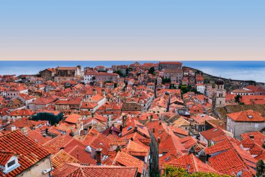 Geniş açılı bir çekim, Adriyatik Denizi 'nin derin mavi arkaplanına karşı kurulmuş Dubrovnik' in Eski Kenti 'nin ikonik kırmızı çatılarını yakalıyor. Hırvatistan