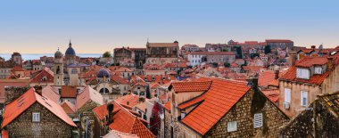 A wide panoramic view of the iconic red-roofed historic houses in the Old Town, captured from the city walls under a clear blue sky. Dubrovnik, Croatia
