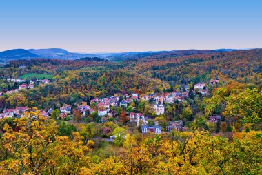 Thüringen Ormanı 'nın canlı sonbahar renkleriyle çevrili Eisenach kasabasının renkli evleri ve mimarisinin manzarası. Almanya