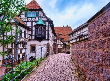 Bahçenin manzarasında Wartburg Şatosu 'nda kaldırım taşları ve geleneksel yarı kereste ön cepheleri var. Eisenach, Almanya