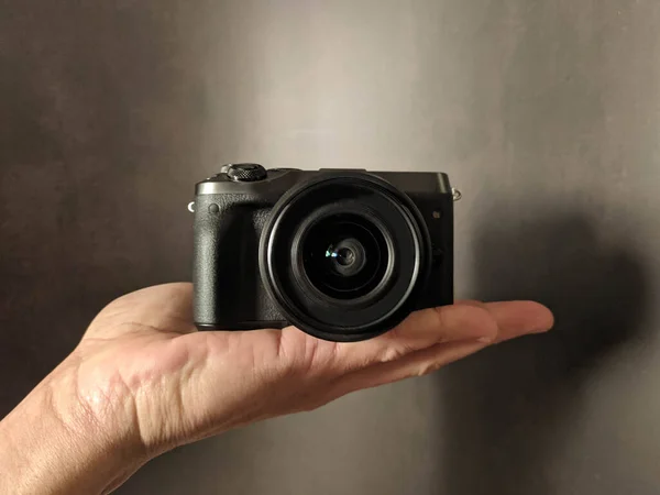 Black photocamera in hand background — Stock Photo, Image