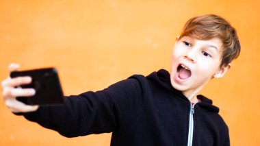 Sarışın çocuk portresi. Hücresel turuncu arka plan.