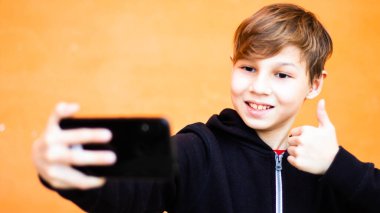 Sarışın çocuk portresi. Hücresel turuncu arka plan.