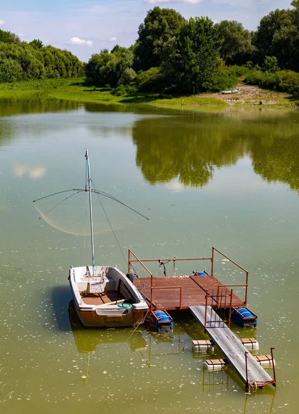 Зеленая лагуна с причалом и лодкой в сельской местности — стоковое фото