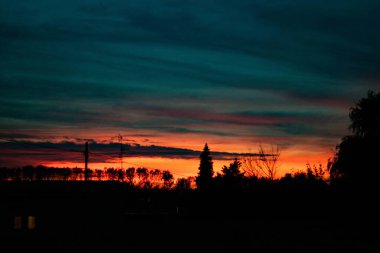 İtalya 'nın Padana ovasında bir köyde bulutlar arasında gün batımı