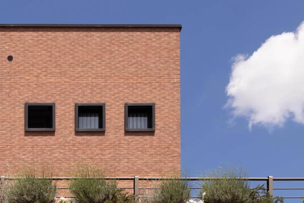 Fachada de ladrillo con tres ventanas, cielo azul y una nube, parma. Italia —  Fotos de Stock