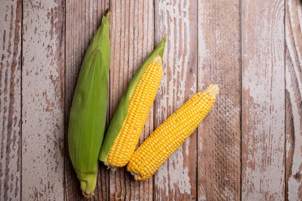 Färsk majs kolvar på platt trä bakgrund — Stockfoto