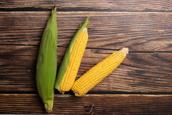 Färsk majs kolvar på platt trä bakgrund — Stockfoto