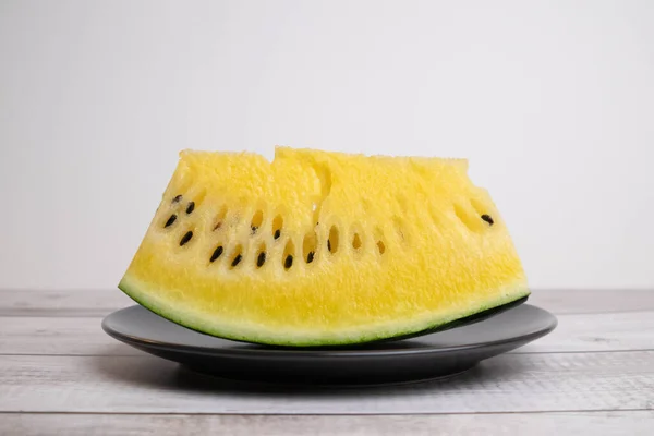 Žlutý meloun na černém talíři, mysli jinak Royalty Free Stock Fotografie