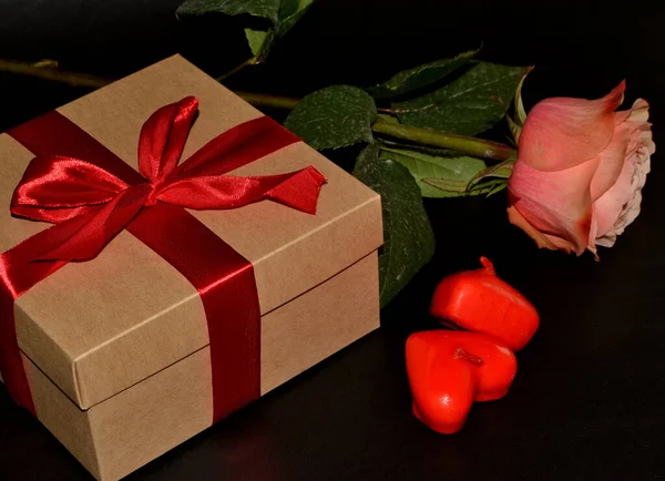 Pudełko Czerwonym Łukiem Różową Różą Aromatycznymi Świecami Czarnym Tle — Zdjęcie stockowe