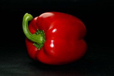 Red Paprika 'nın stüdyo fotoğrafı siyah arka planda izole edilmiş.