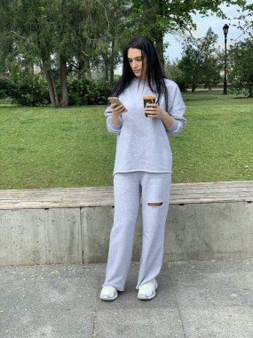 Parkta cep telefonunu kullanan bir kadın.