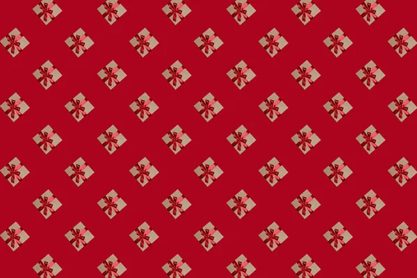 赤い背景にリボンで縁取られた弓のついたギフトボックスのパターン — ストック写真